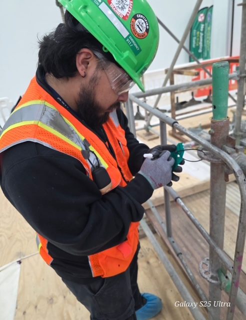 ADF safety technician in hard hat and hi-vis vest inspecting scaffolding